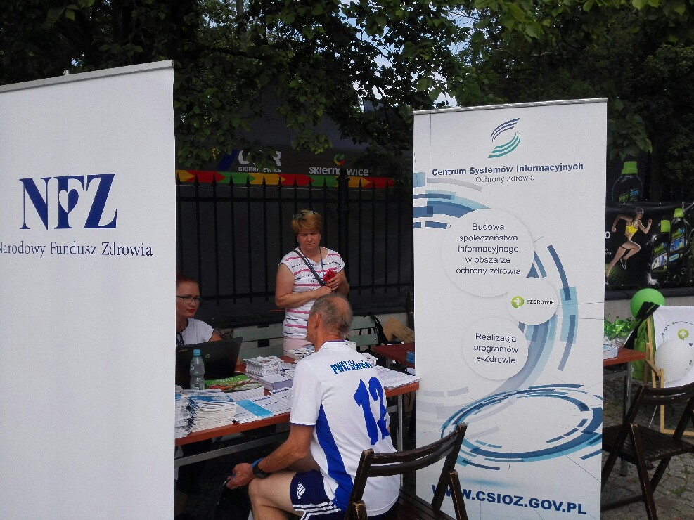 Zdjęcie nr 2 - stoisko ŁOW NFZ, przy którym siedzi uczestnik biegu